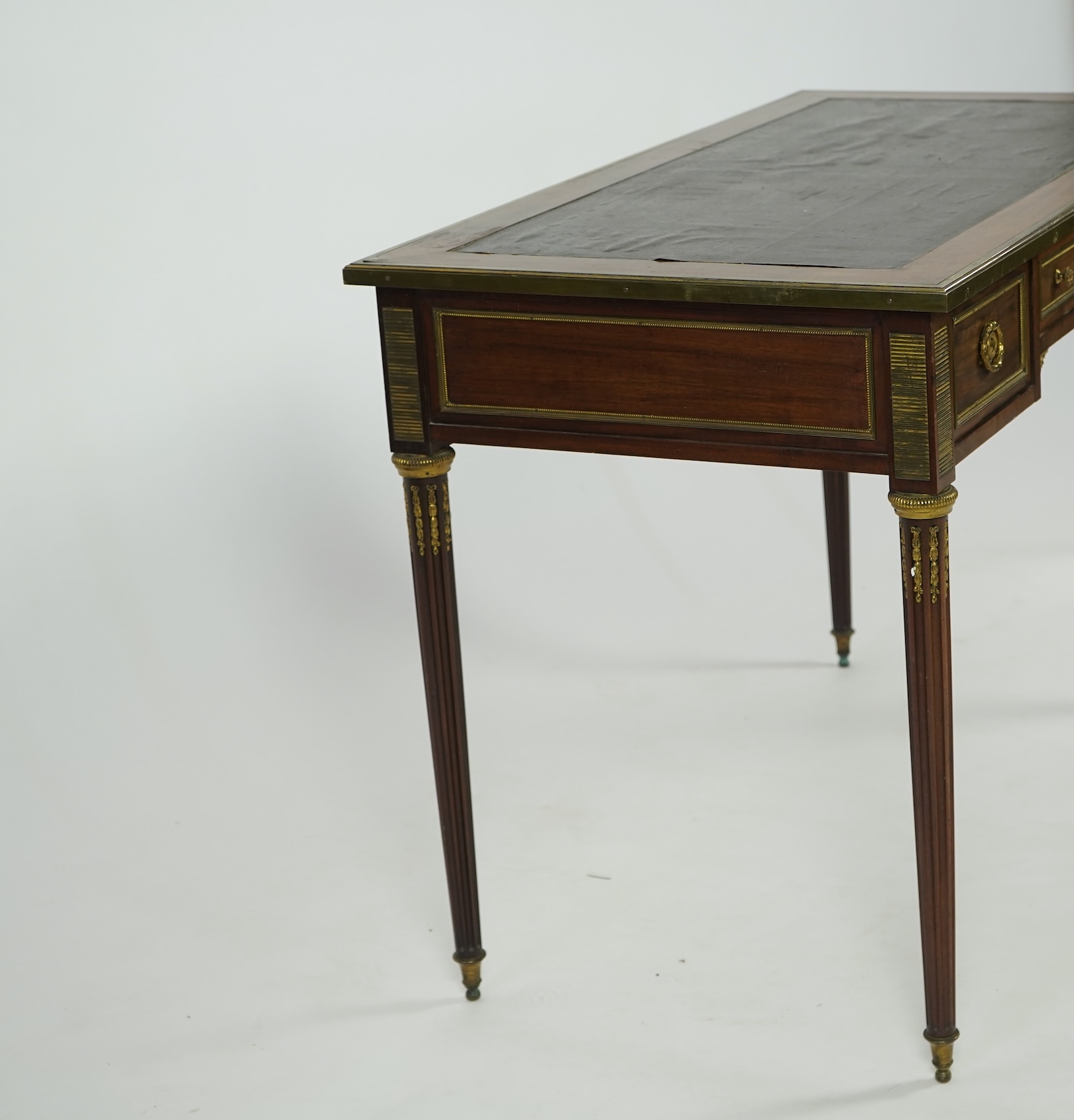 An early 20th century Louis XVI style brass mounted mahogany writing table